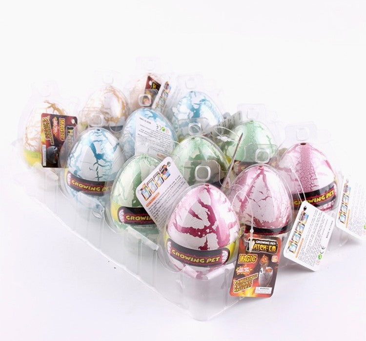 Twelve individually wrapped pastel-colored dinosaur eggs with product tags arranged in a clear tray.